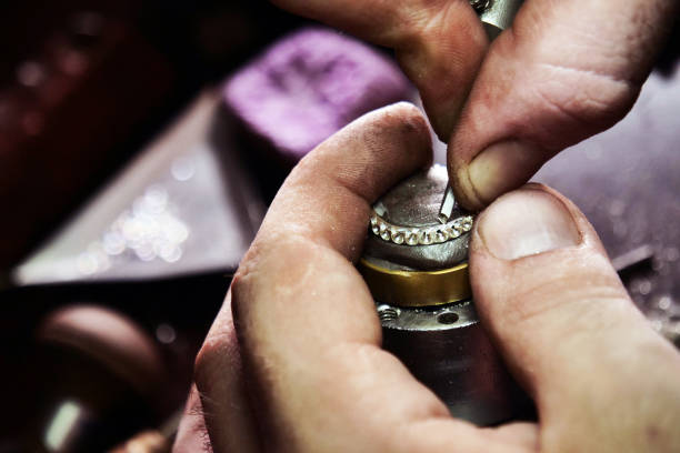istock Close up of a goldsmith's hand making a gold or silver ring or a diamond using goldsmith's tools 1214875410