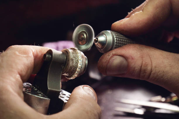 istock Close up of a goldsmith's hand making a gold or silver ring or a diamond using goldsmith's tools 1214875716
