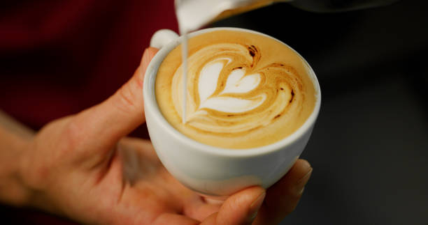 istock Macro of a barman while making a cappuccino next to the coffee machine in a typical italian bar 1214879262