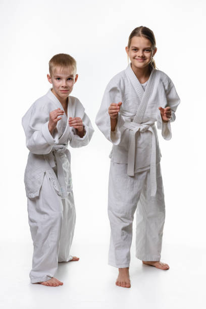 istock Judo boy and girl students in a rack, white background 1214879324