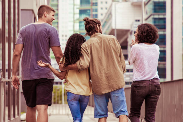istock Back view of young people walking on street 1214879620