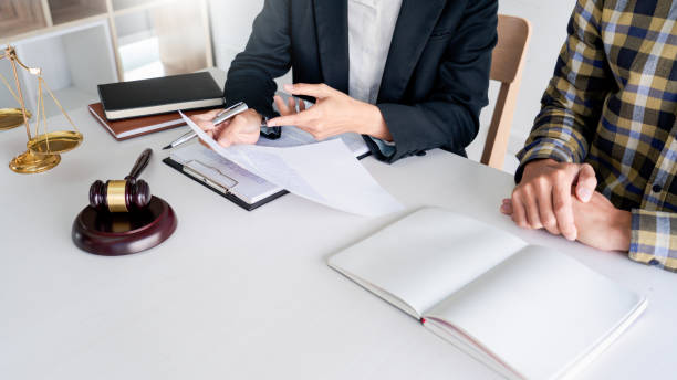 istock Midsection Of Lawyer Discussing Document With Man In Office 1214885148