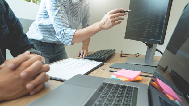 istock Midsection Of Male Coworkers Discussing Over Computer In Office 1214885243