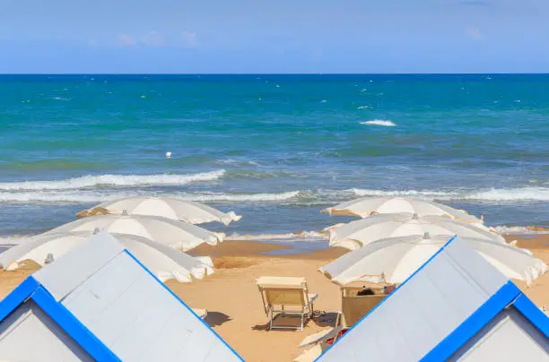 Photo of Umbrella on sandy beach with blue sea: relax on the beach.