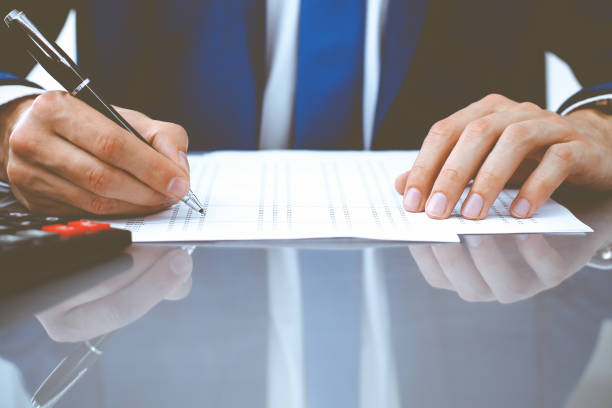 istock Bookkeeper or financial inspector hands making report, calculating or checking balance. Internal Revenue Service inspector man checking financial document. Business, tax and audit concepts 1214886713
