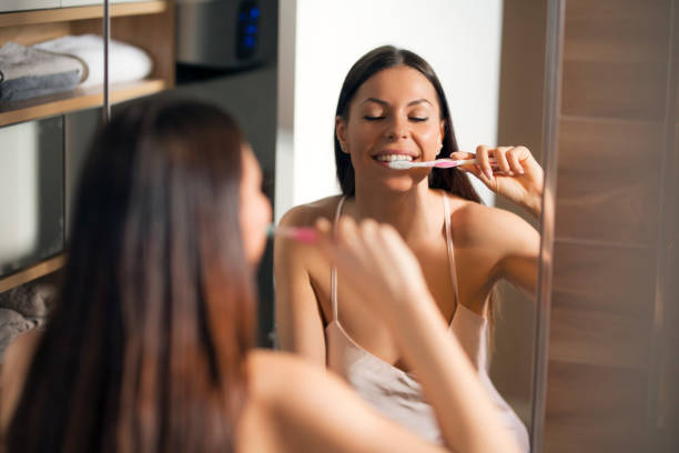 istock Young woman in bathroom washing her teeth. 1214886990