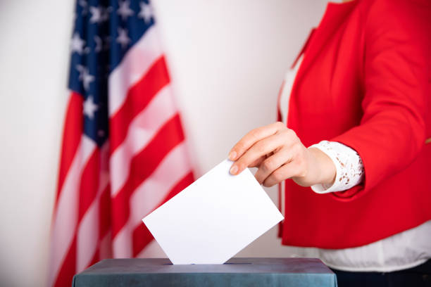 istock American voter putting ballot into voting box. 1214887702