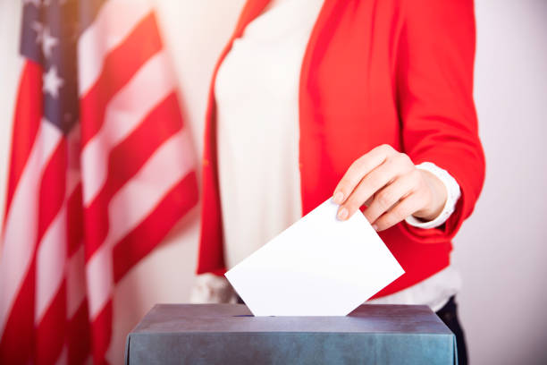 istock American voter putting ballot into voting box. 1214887866