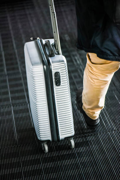 istock Man with suitcase on escalator stairs. 1214887944