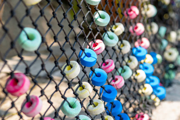 istock Colorful and round soft decorations on the net fence 1214888567