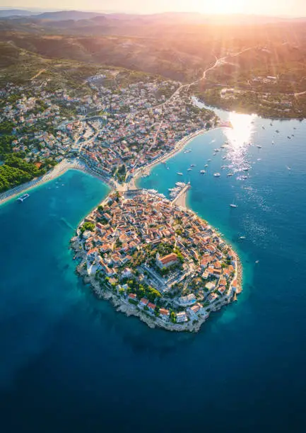 Aerial view of Primosten old town on the islet, amazing sunny landscape, Dalmatia, Croatia. Famous tourist resort on Adriatic sea coast, vertical travel background