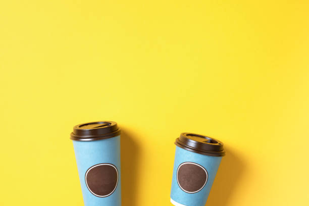 istock Take away tea or coffee cup on yellow background. Top view. Copy space. Minimal composition, layout for design. Coffee concept 1214889028