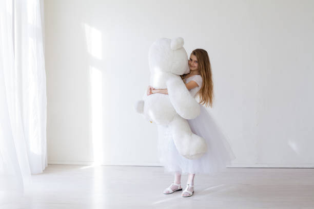 Girl holds white teddy bear