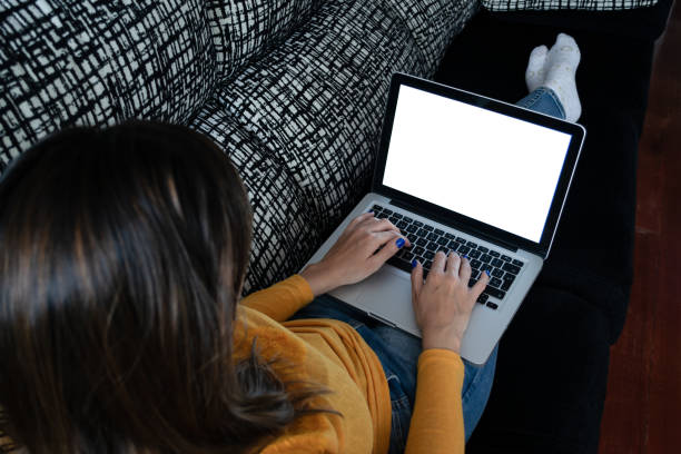 istock Girl studying on the couch, laptop with a blank screen. Perfect image for mockup 1214892757