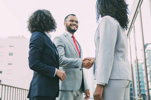 istock Friendly colleagues greeting each other near office building 1214893195