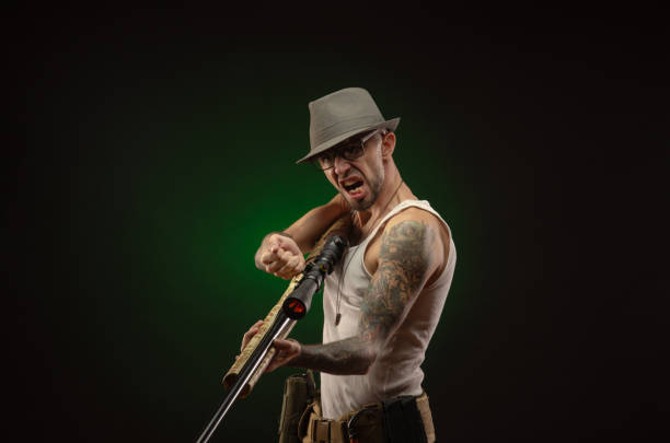 istock an athletic guy with a tattoo poses with a shotgun 1214894644