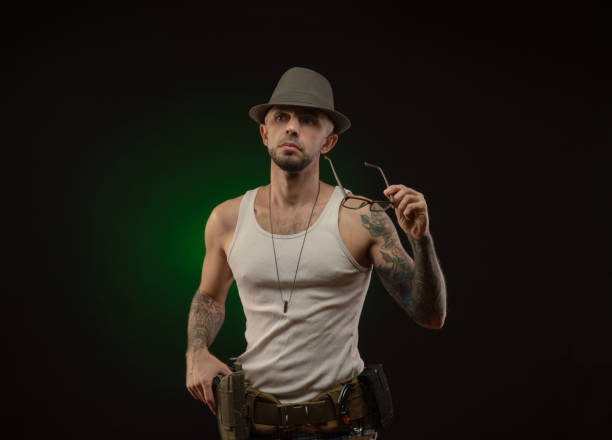 istock an athletic guy with a tattoo poses with a gun 1214894686