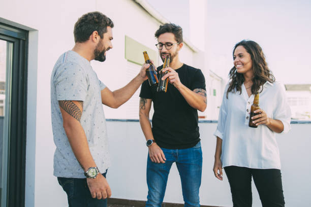 istock Happy positive friends celebrating and toasting beer 1214894786