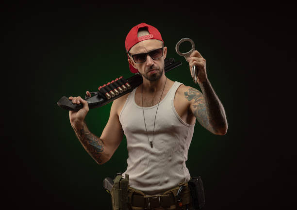 istock an athletic guy with a tattoo poses with a shotgun 1214894798