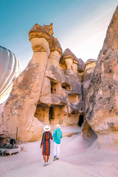 jeune couple heureux en vacances en turquie cappadoce, formations rocheuses dans la vallée de moines de pasabag, cappadoce, turquie - dormant volcano photos et images de collection