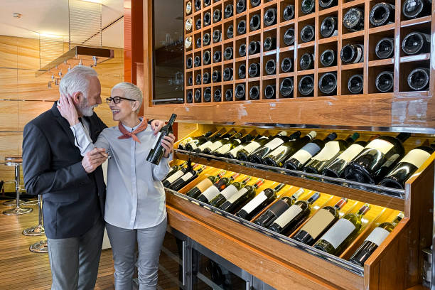 istock Senior rich couple choosing a wine for degustation in a luxurious winery 1214897956