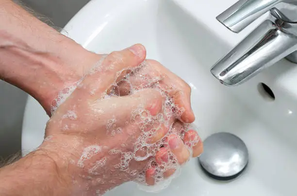 Man washing hands in the bathroom. Hands close up with hand-wash foam. Washing hands rubbing with soap man for corona virus prevention.