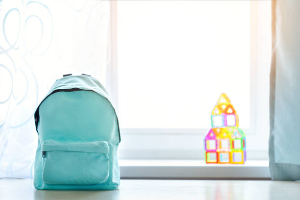 istock Blue school backpack on table over children room interior. 1214898554
