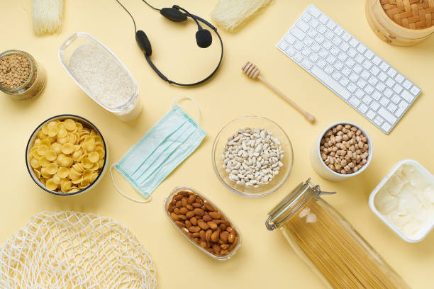 Flatlay with food provision and home office equipment prepared to survive Coronavirus COVID 19 pandemic at the time of cuarentine and home isolation. Pasta, chickpeas, rice, nuts, keyboard and headphone set. flatlay con suministro de alimentos y equipo de oficina en el hogar preparado para sobrevivir coronavirus covid 19 pandemia en el momento de la cuarentina y el aislamiento del hogar. pasta, garbanzos, arroz, nueces, teclado y auriculares.