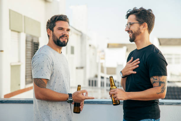 istock Positive male friends chatting and drinking beer 1214899879