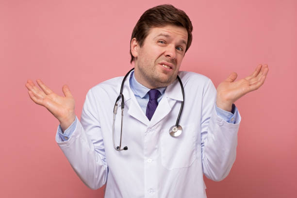 Caucasian mature man in white coat, doctor or intern throws up his hands stock photo