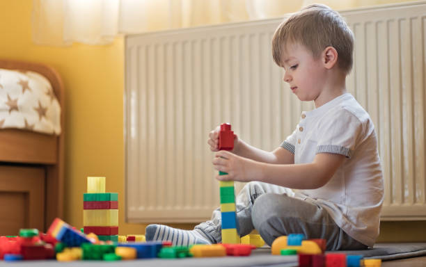 istock Beautiful boy playing with toy blocks 1214900841