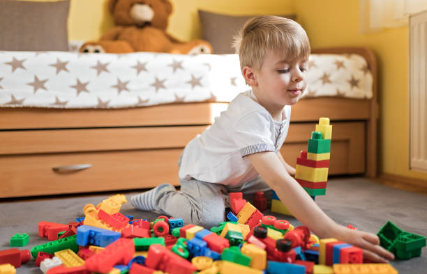 istock Cute boy playing with toy blocks 1214900992