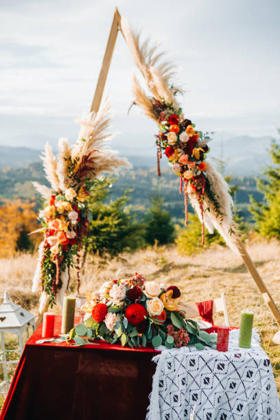 istock Triangular wooden arch with composition of pampasian grass, dahlia and roses. Decorative floristry 1214904099