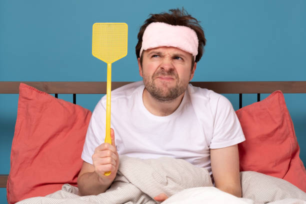istock man holding a fly swatter wanting to kill annoying mosquito 1214904259
