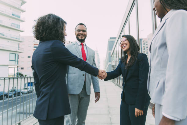 istock Happy female manager welcoming partners outside 1214904966