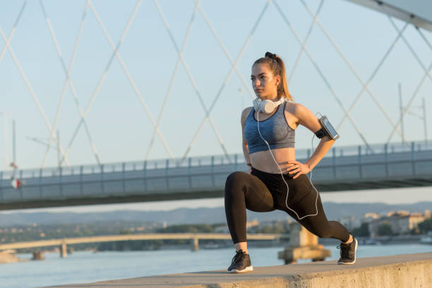 istock Girl with headphones exercising 1214906349