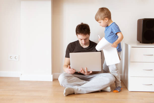 istock Father working at home office while the kids are playing. Home office and telecommuting concept 1214907327