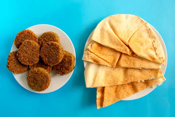 Photo of Pita bread and falafel on blue background.