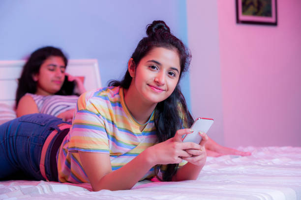 garota teeange verificando foto de estoque de mídia social - one teenage girl only on the phone bed lying on front - fotografias e filmes do acervo