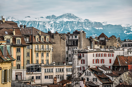 View over the meadows of Kleine Scheidegg alpine pass in Switzerland with view on the snowcapped Jungfraujoch in the Bernese Alps with signpost in front pointing to various mountain passes and cities