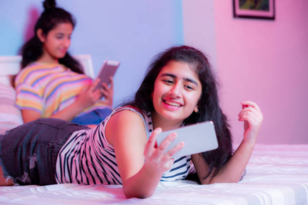 garota teeange tirando foto de estoque de selfie - one teenage girl only on the phone bed lying on front - fotografias e filmes do acervo