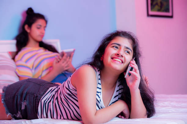 ragazza teeange che parla alla foto d'archivio del telefono - one teenage girl only on the phone bed lying on front foto e immagini stock