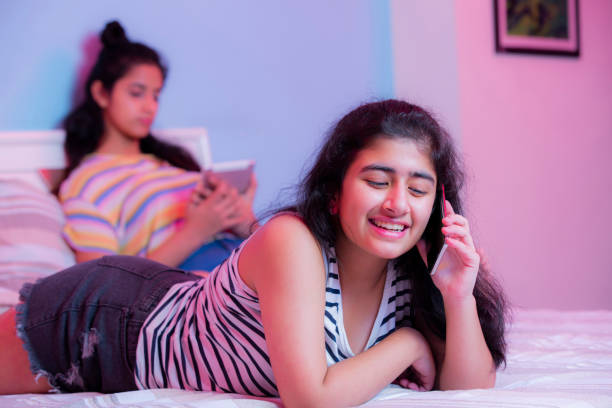 garota teeange falando em telefone stock foto - one teenage girl only on the phone bed lying on front - fotografias e filmes do acervo