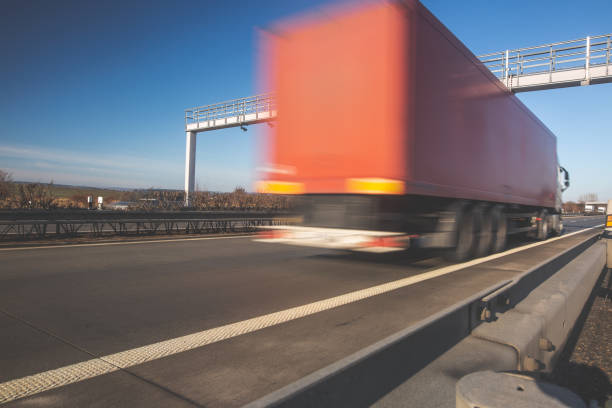 istock Truck passing through a toll gate on a highway, highway charges, motion blurred image 1214912204