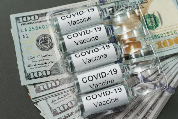 Vials of vaccine from Covid-19 lie on stack of money. Expensive drugs for coronavirus Vials of vaccine from Covid-19 lie on stack of money. Expensive drugs for coronavirus. corruption photos stock pictures, royalty-free photos & images