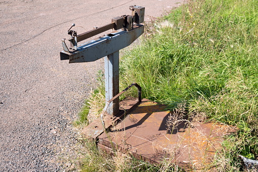 Old mechanical goods scales stand on the grass, on the side of the road, in summer