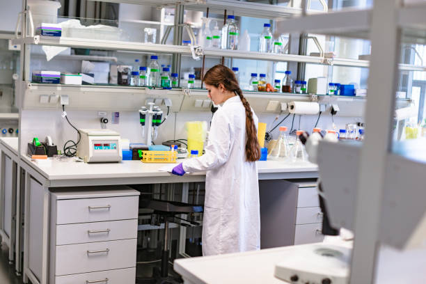 istock Girl scientist studying notes near lab equipment 1214913489