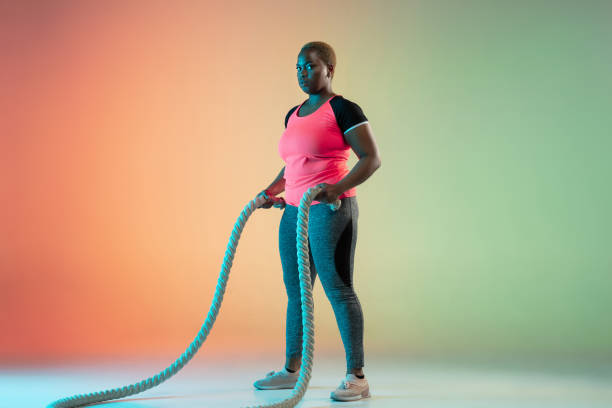 istock Young african-american plus size female model's training on gradient background 1214913741