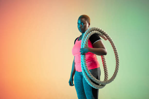 istock Young african-american plus size female model's training on gradient background 1214913760