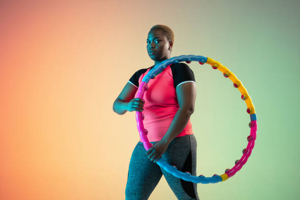 istock Young african-american plus size female model's training on gradient background 1214913767